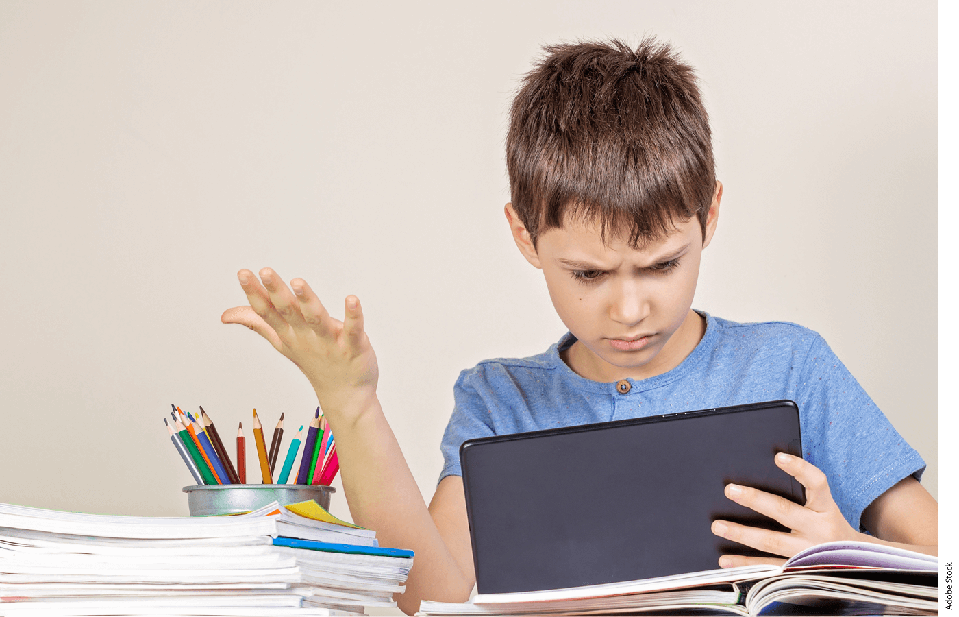 Photo of a confused student holding a tablet