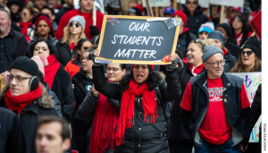 Thousands of striking Chicago Teachers Union and their supporters march around City Hall in October 2019. One person in front holds up a sign that reads, "Our Students Matter."