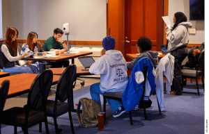 Debate judges Yerim Lee, Sharon Lee, and Andrew Abrego take notes as students from Josiah Quincy Upper School and Neighborhood House Charter School square off in a championship qualifying debate in Boston.