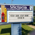 School sign which reads "Stay Safe Stay Home Covid 19"