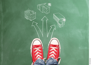 A pair of sneakers standing on a chalkboard, on which directions are drawn in chalk, pointing towards three different school buildings