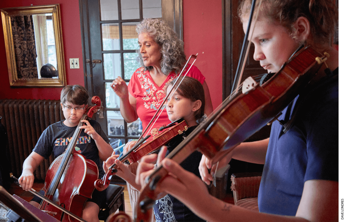 Caprice Corona assists her three children during a music lesson at home.