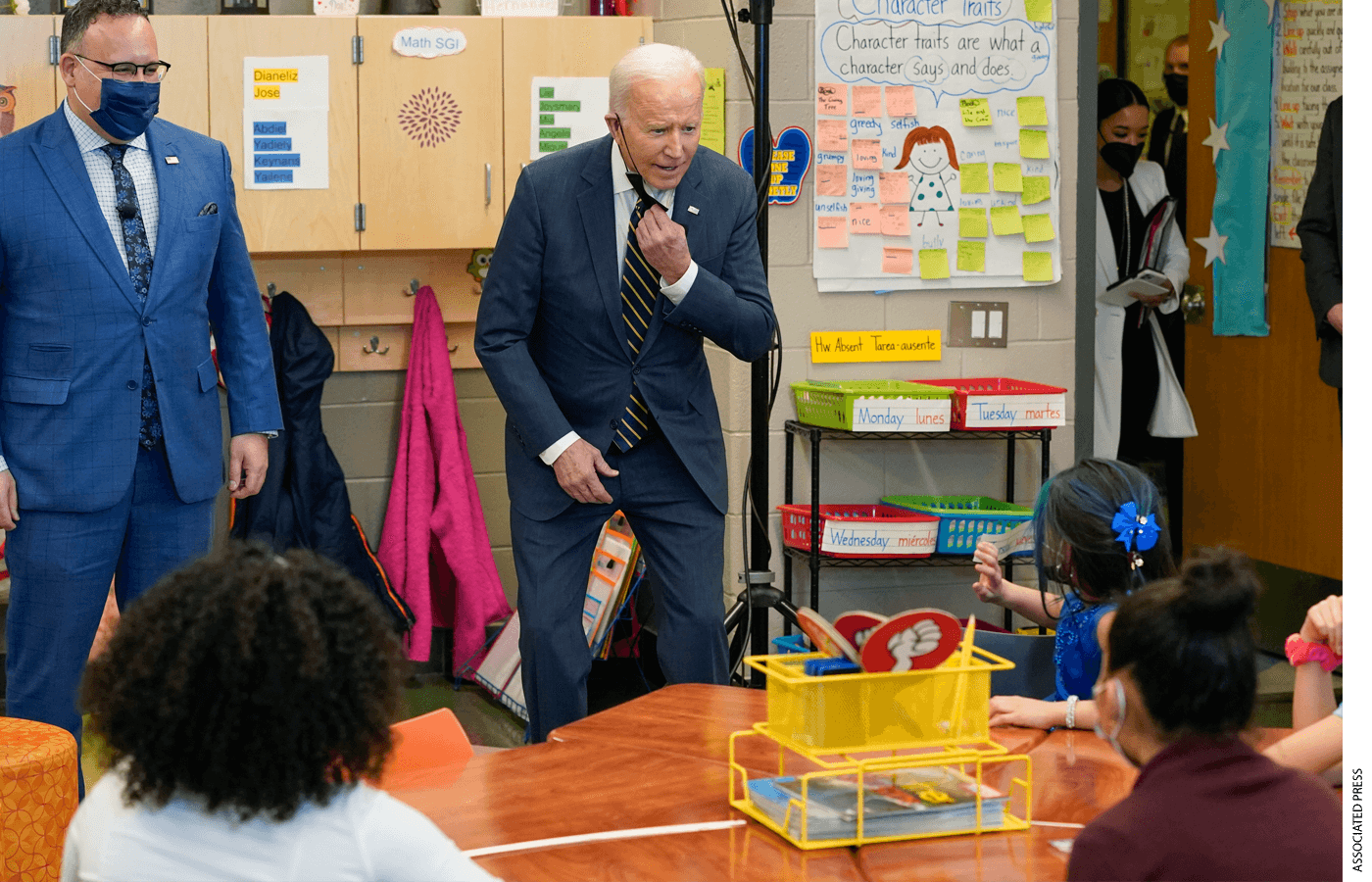 Education Secretary Miguel Cardona watches as President Joe Biden speaks to students in a classroom during a visit to Luis Muñoz Marin Elementary School in Philadelphia, Friday, March 11, 2022.