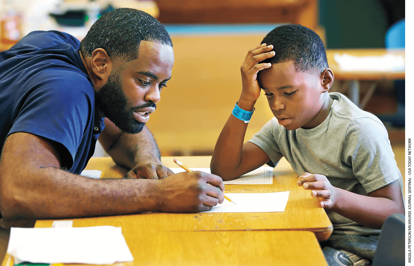 Marquise Mayes, 8, works on math homework with his teacher at Lloyd Barbee Montessori School in Milwaukee, Wisconsin.