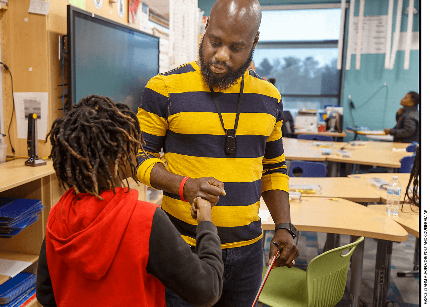 Teacher Tyler White congratulates a 4th-grade student at Stono Park Elementary School in Charleston, South Carolina. The county aims to hire 60 more Black teachers by 2025.