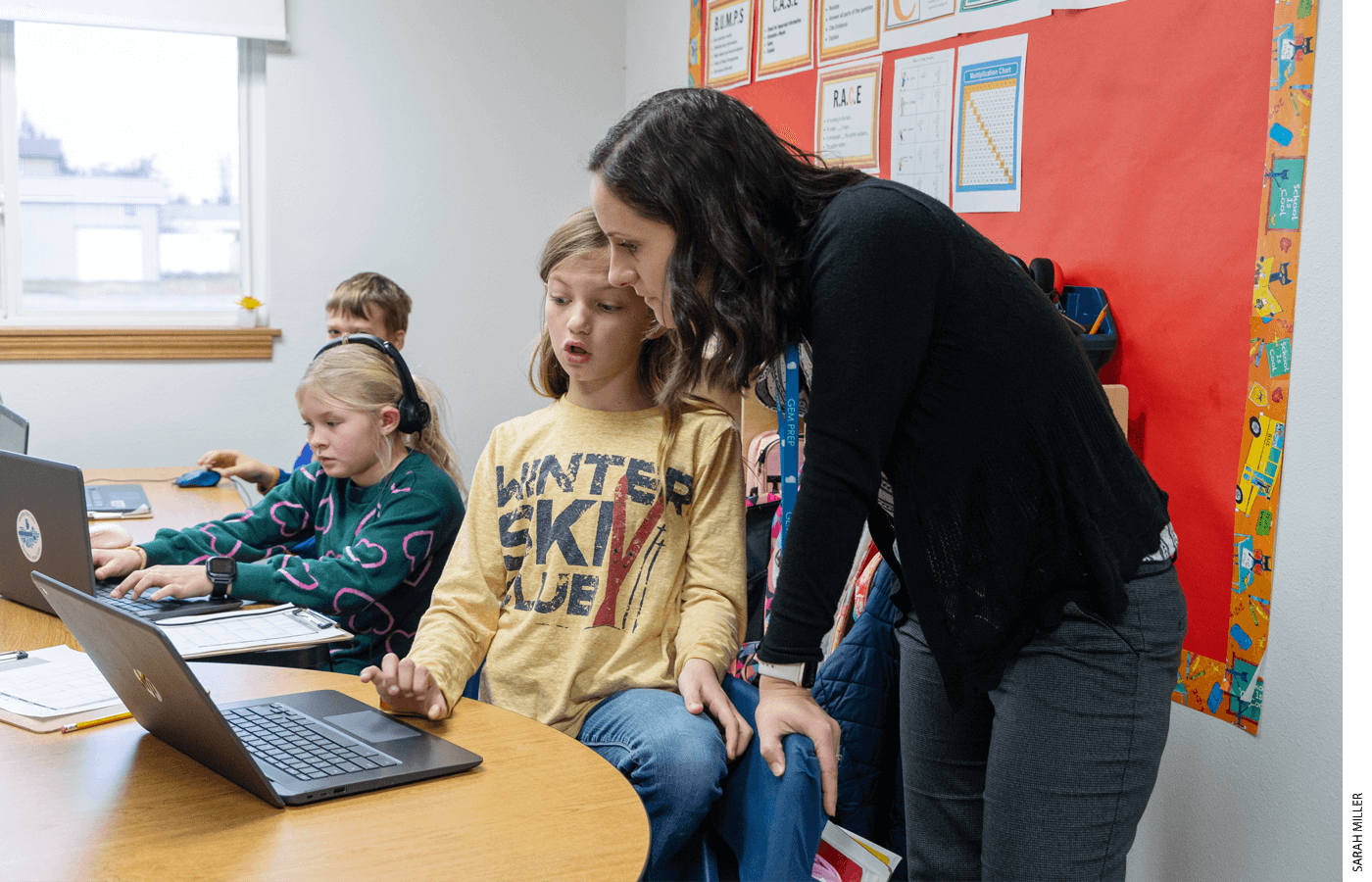 Teacher Bailey Schissler assists fourth-grade student Cora Andean at the Gem Prep Learning Society in Emmett. In its experimental first year, Gem Prep leadership discovered that a successful Learning Society depended on the presence of a consistent, experienced teacher.