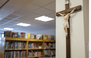 A crucifix hangs on the wall of a library