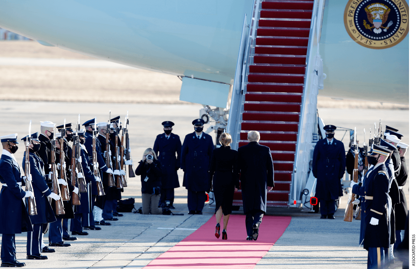 President Donald Trump and first lady Melania Trump are greeted by a military honor guard as they board Air Force One at Andrews Air Force Base, Wednesday, Jan. 20, 2021.