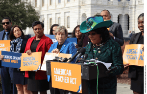 Teachers Union Leaders Becky Pringle and Randi Weingarten look on earlier this month as a member of Congress, Frederica Wilson, speaks about legislation that would raise starting teacher pay to $60,000 a year.