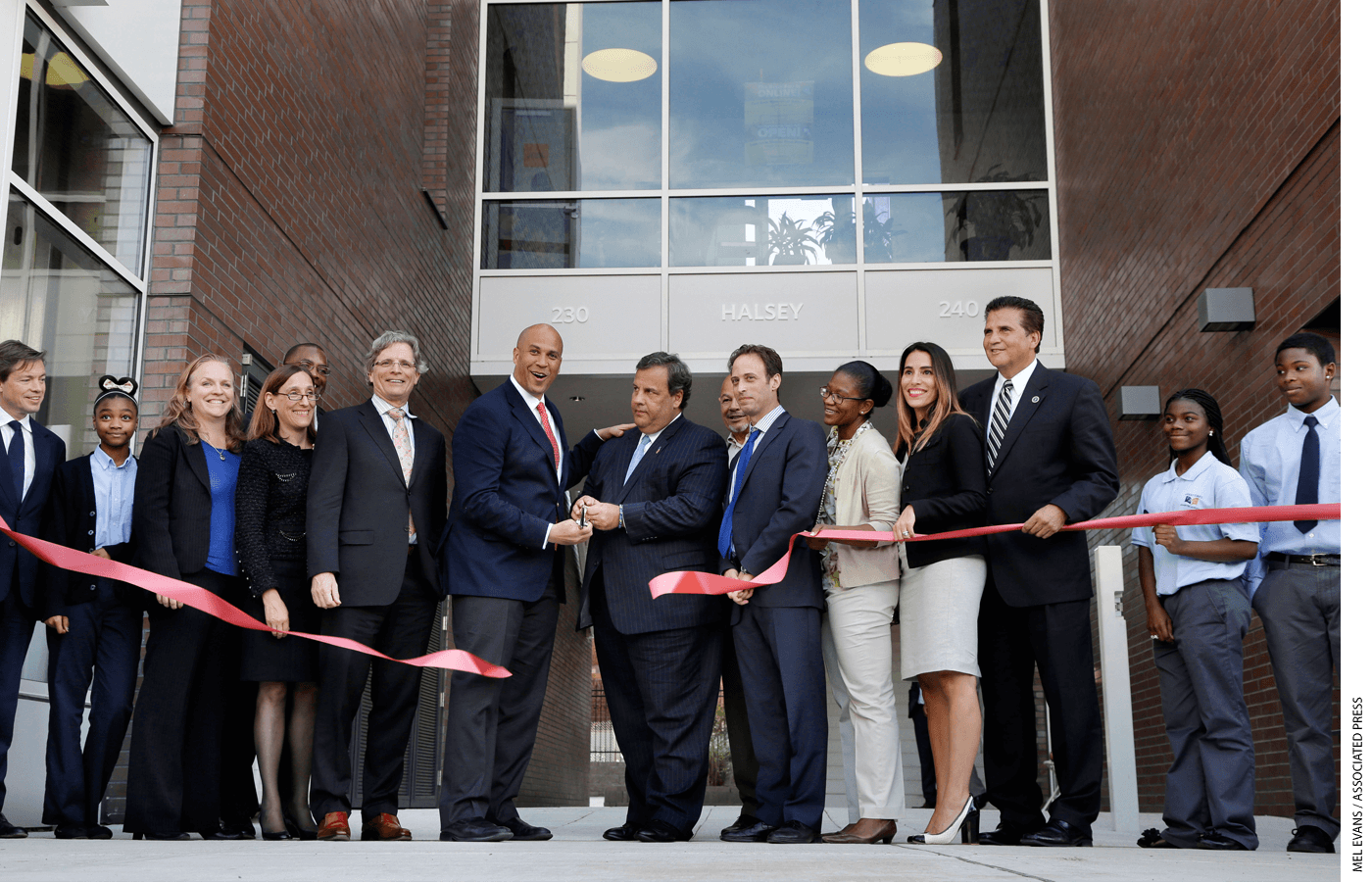 Democratic Newark Mayor and senate candidate Cory Booker, center left and Republican New Jersey Gov. Chris Christie, center right, joins others in Newark, N.J., Wednesday, Sept. 25, 2013, as they cut a ribbon during an opening ceremony for Newark charter schools.