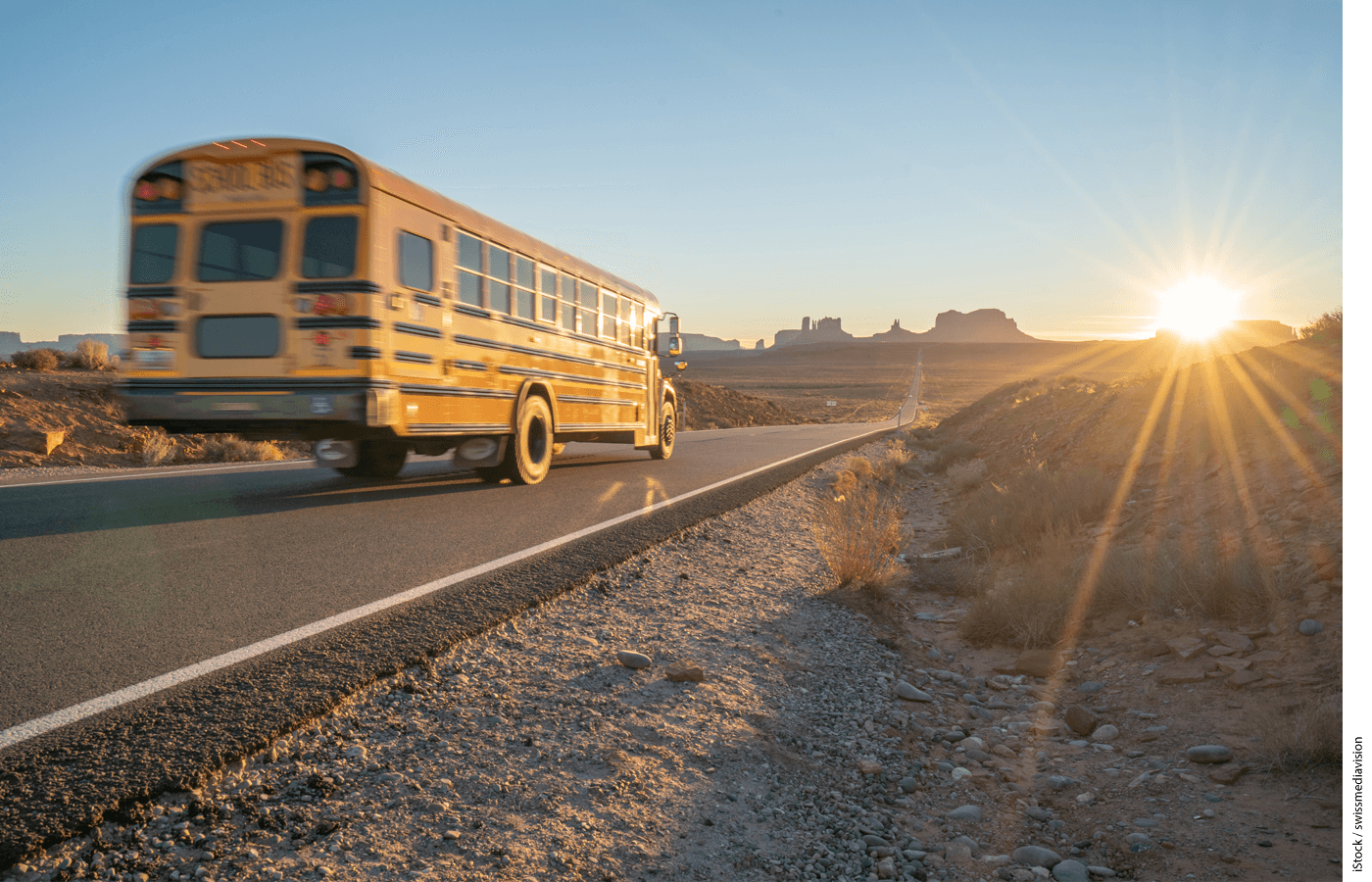 Photo of a bus driving down a desert highway